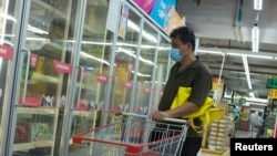 一名男子戴口罩在超市選購冷凍食品。（2020年8月13日）