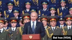 俄罗斯总统普京去年夏季在一次对外军事活动上发表讲话。背景是亚历山大红旗歌舞团。