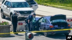 国会警察站在一辆冲击路障的小轿车边。(2021年4月2日)