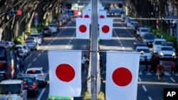 日本東京一條商業街上懸掛的日本國旗. (2023年1月3日)